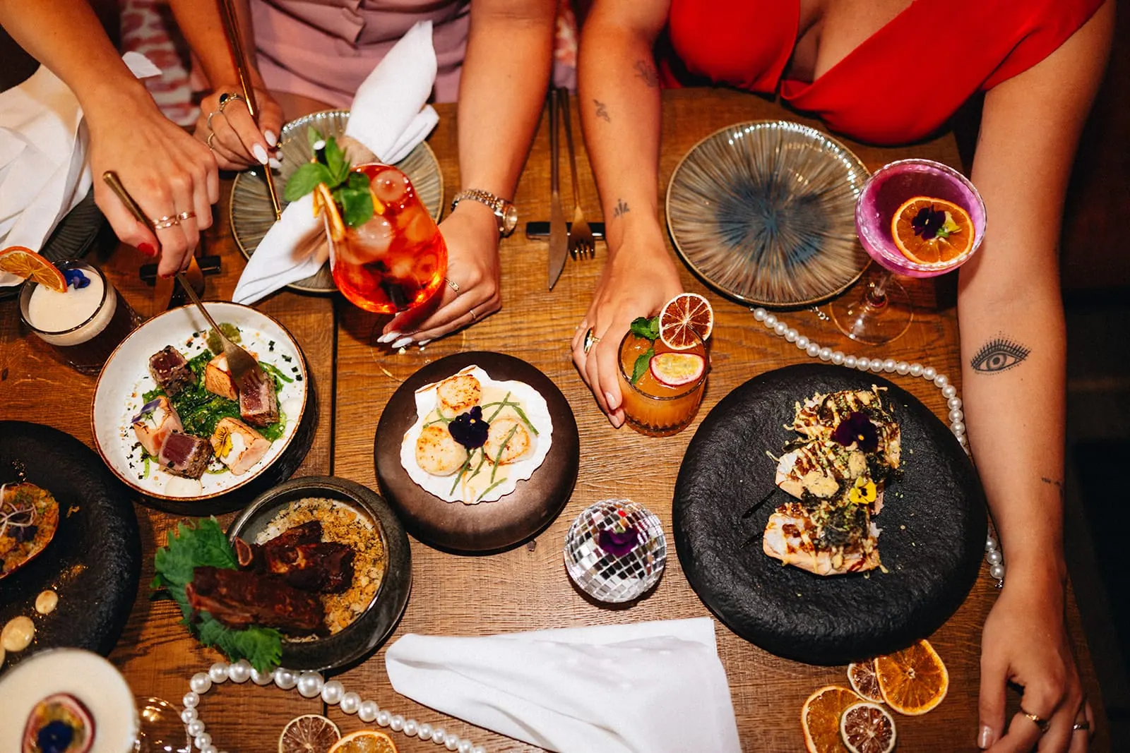 Borrelmoment met hapjes en cocktails op een houten tafel bij Miss Johnsen