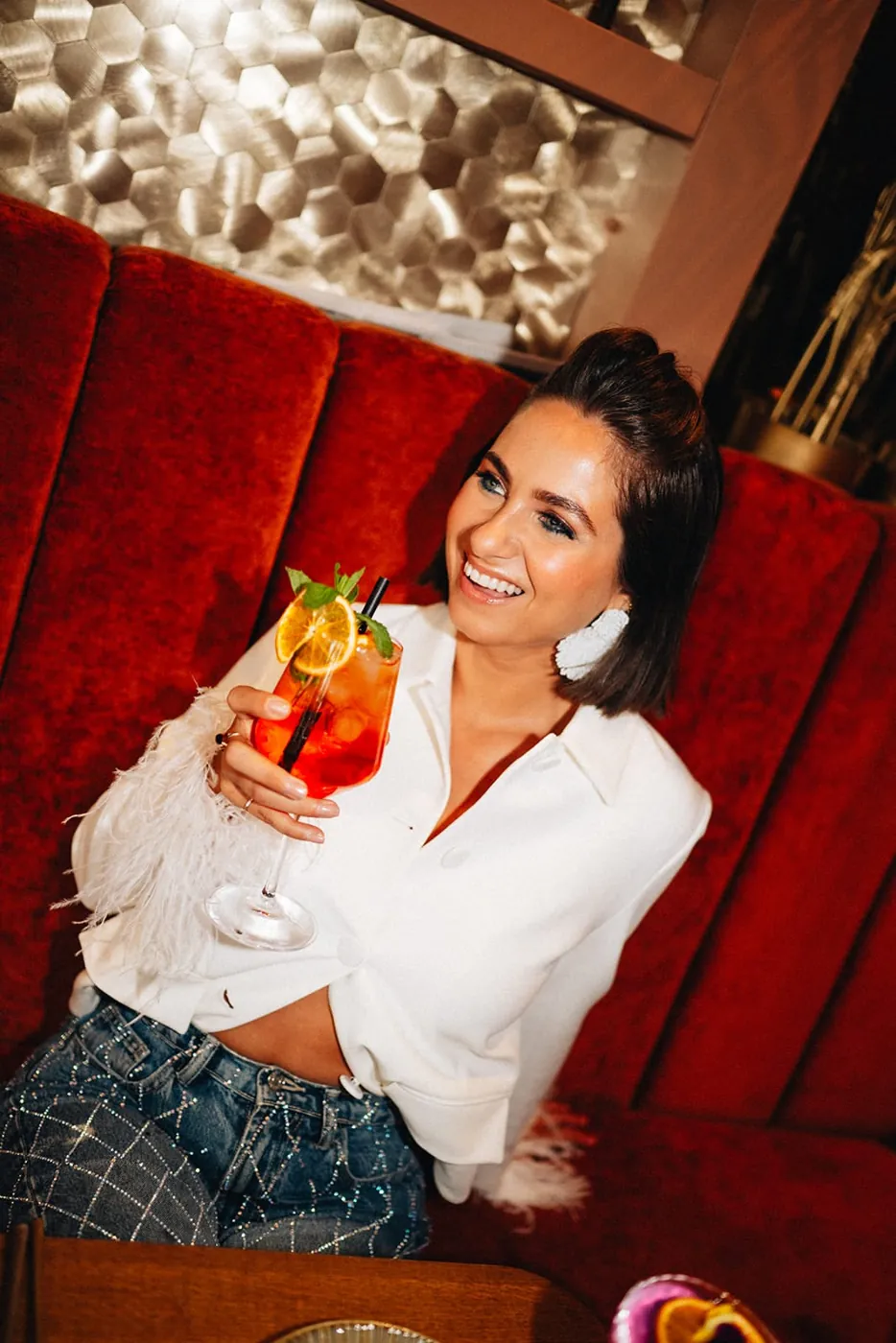Gast met een cocktail in de rode booth bij Miss Johnsen